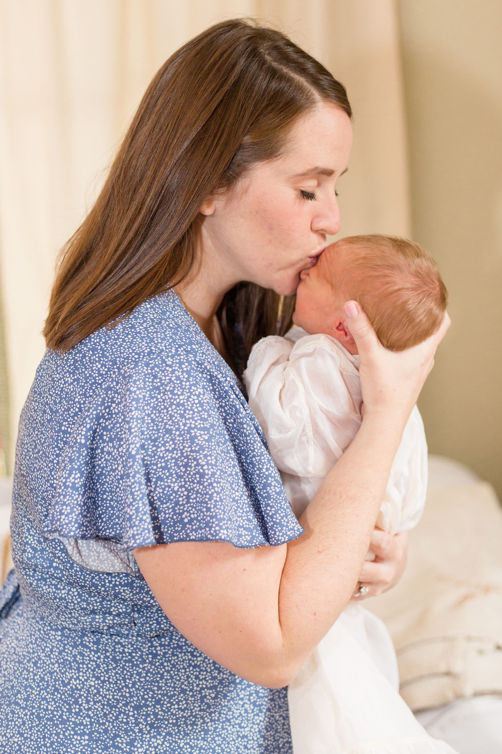 mom kisses baby boy during Nashville lifestyle newborn portraits
