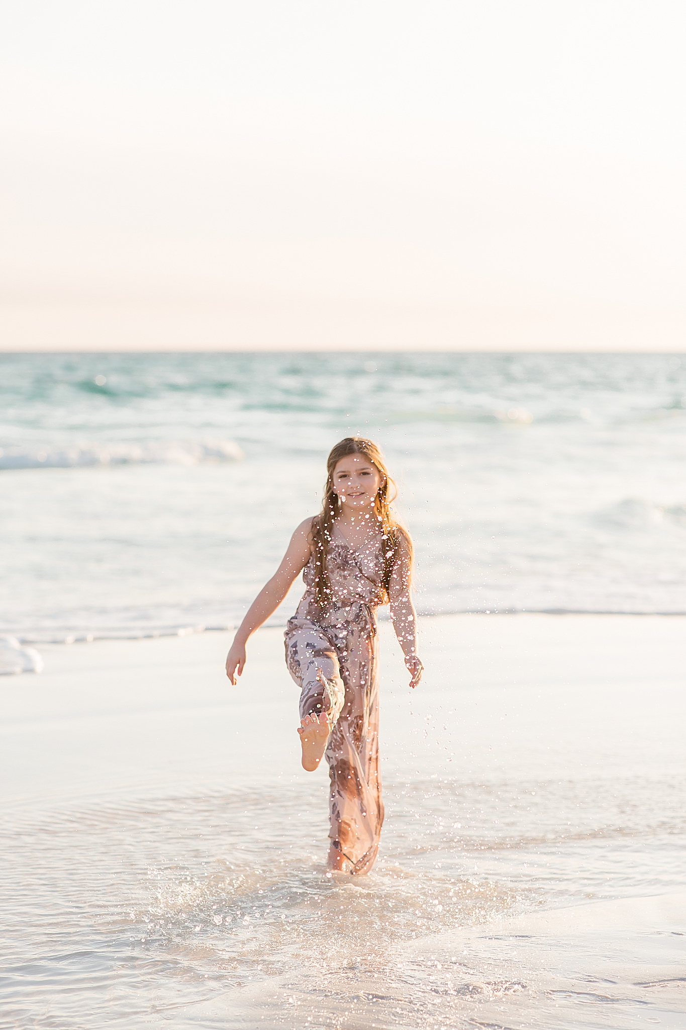 young girl kicks ocean during 30A Florida Beach Family Portraits