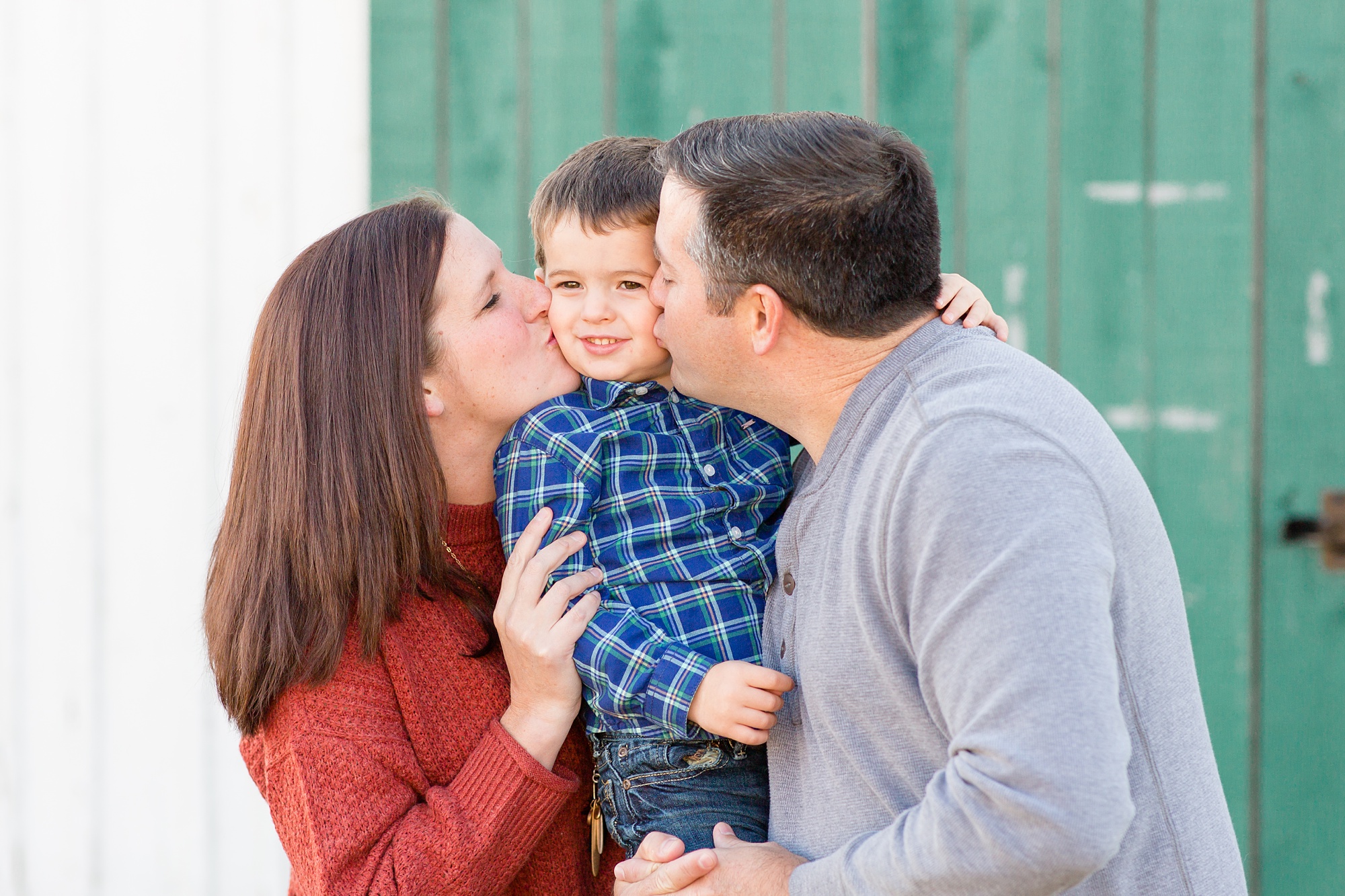 parents kiss toddler during Franklin TN family photos