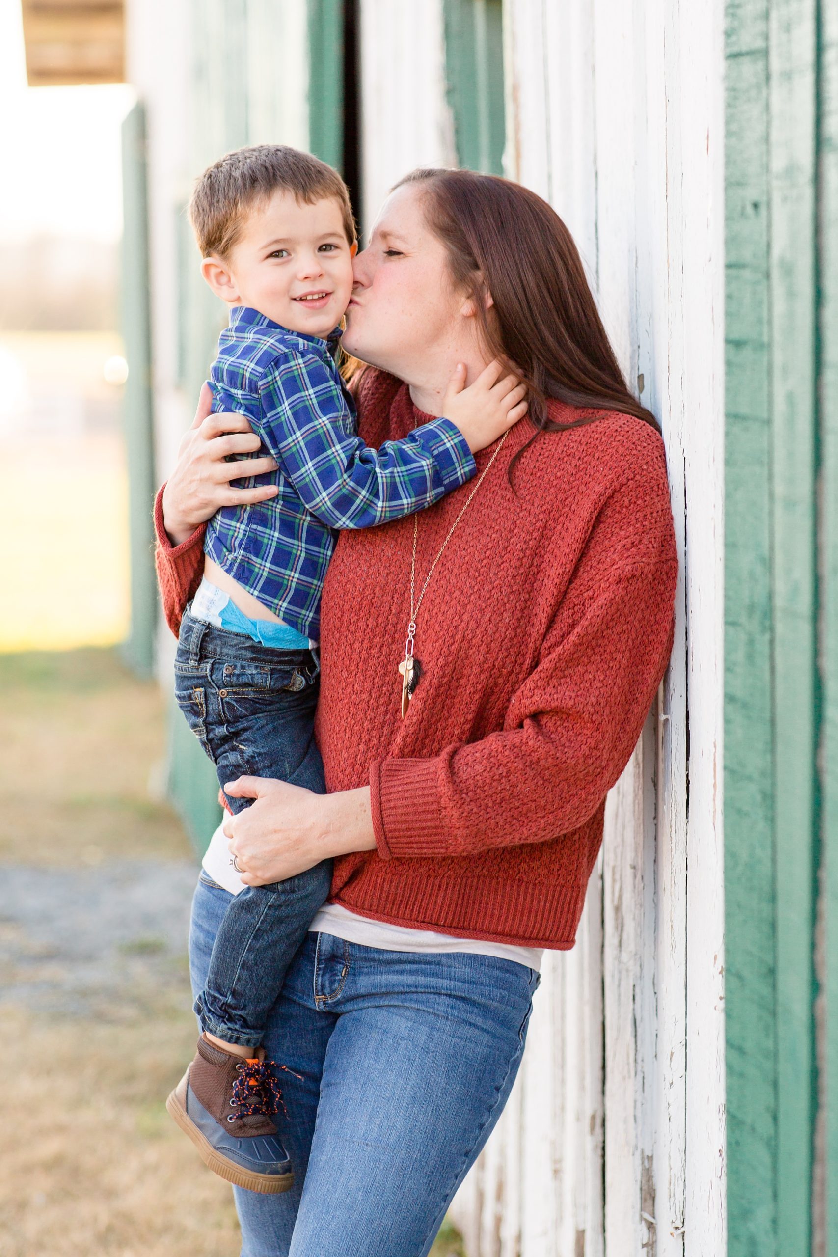 mom kisses son's cheek during Harlinsdale Farm family portraits