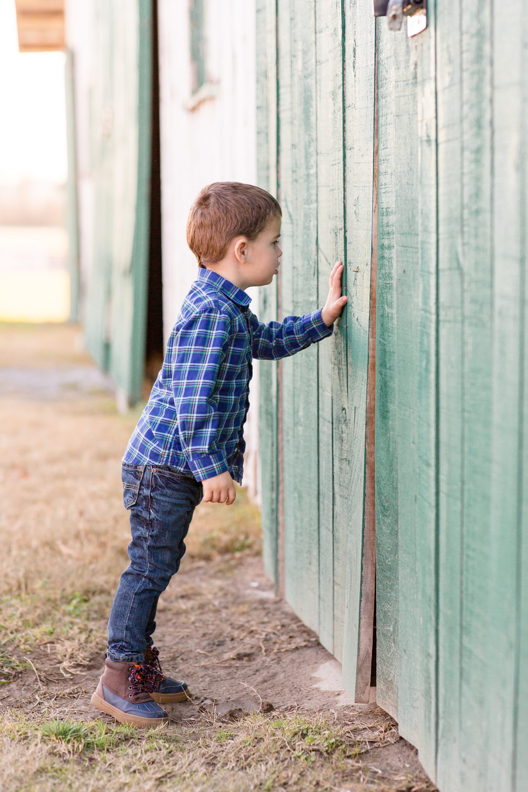 toddler looks at side of green barn in Franklin TN