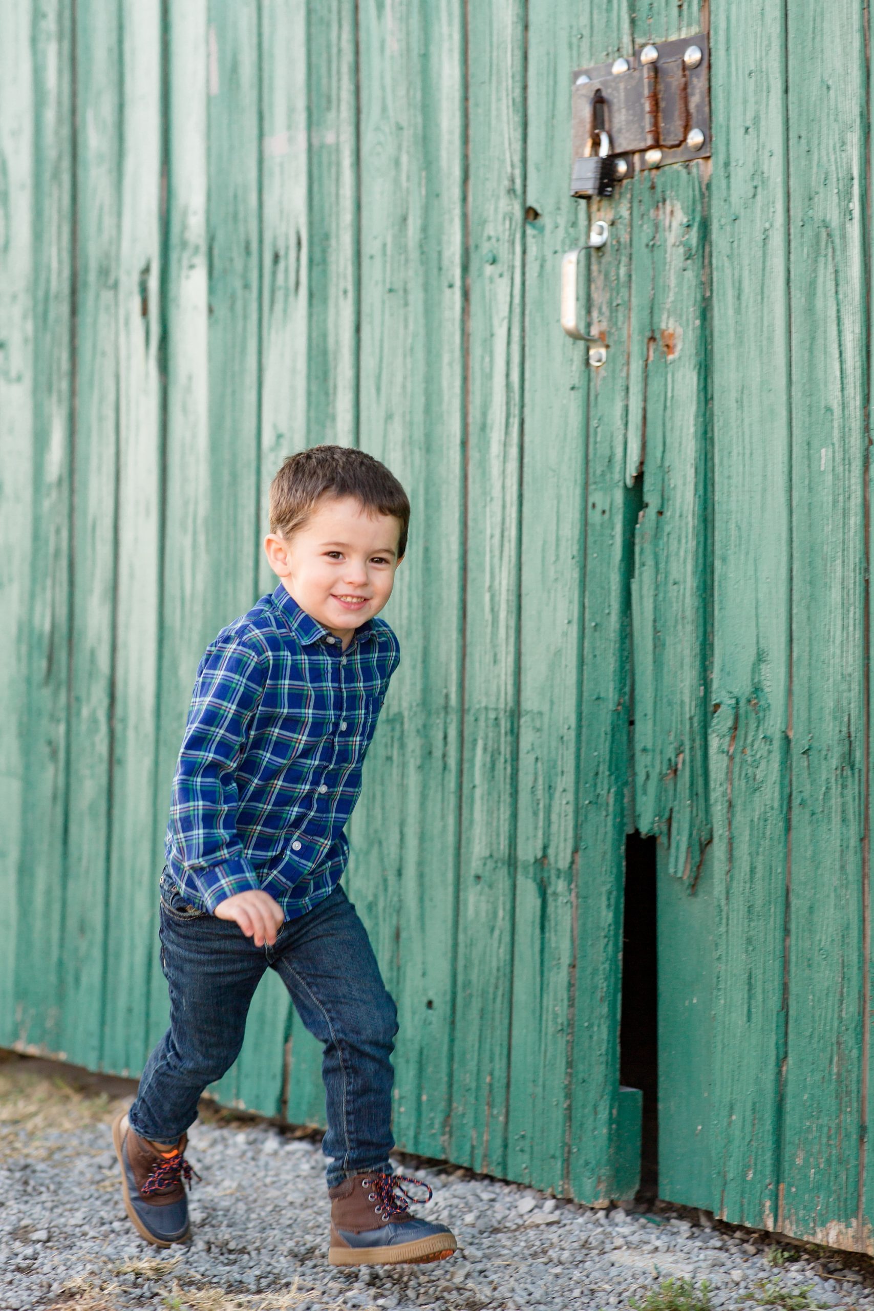 toddler runs by green barn on Harlinsdale Farm