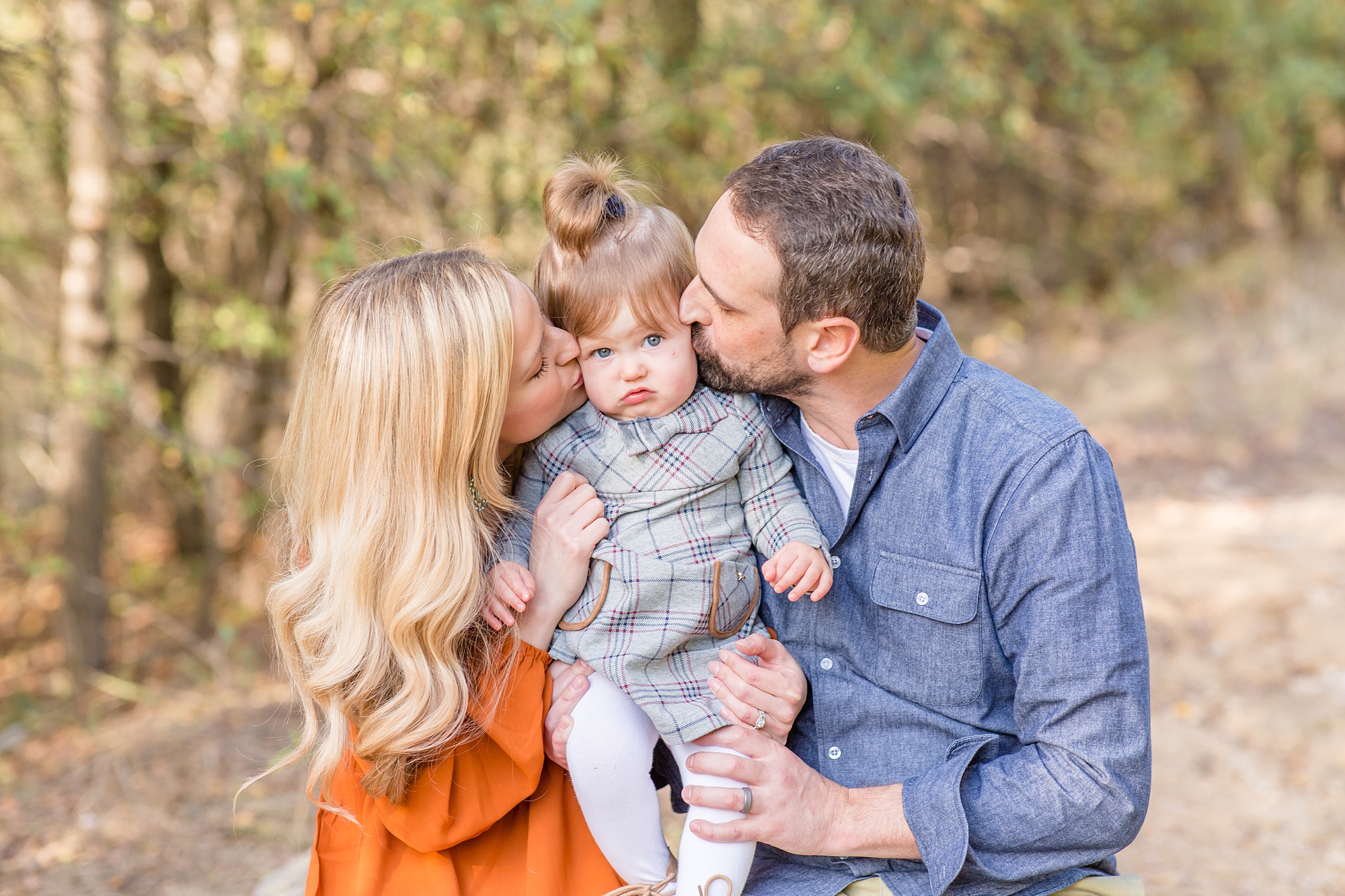 parnets kiss daughter during family portraits