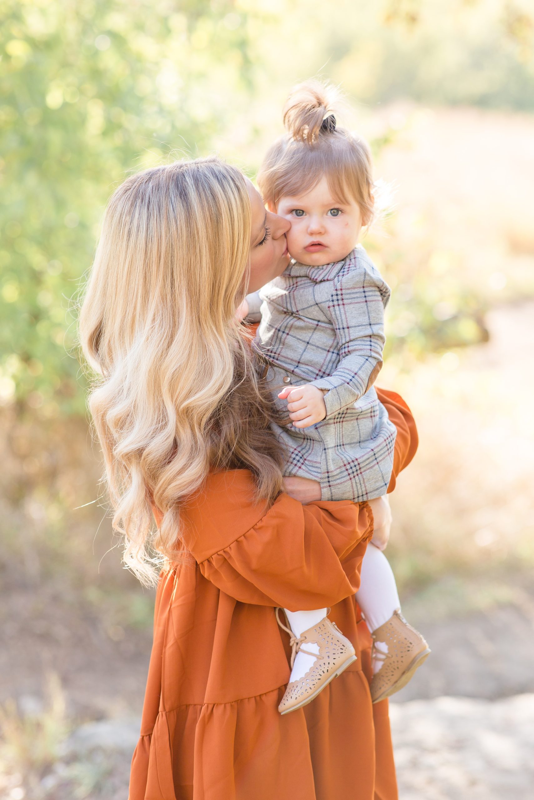 mom kisses toddler's cheek during TX family photos
