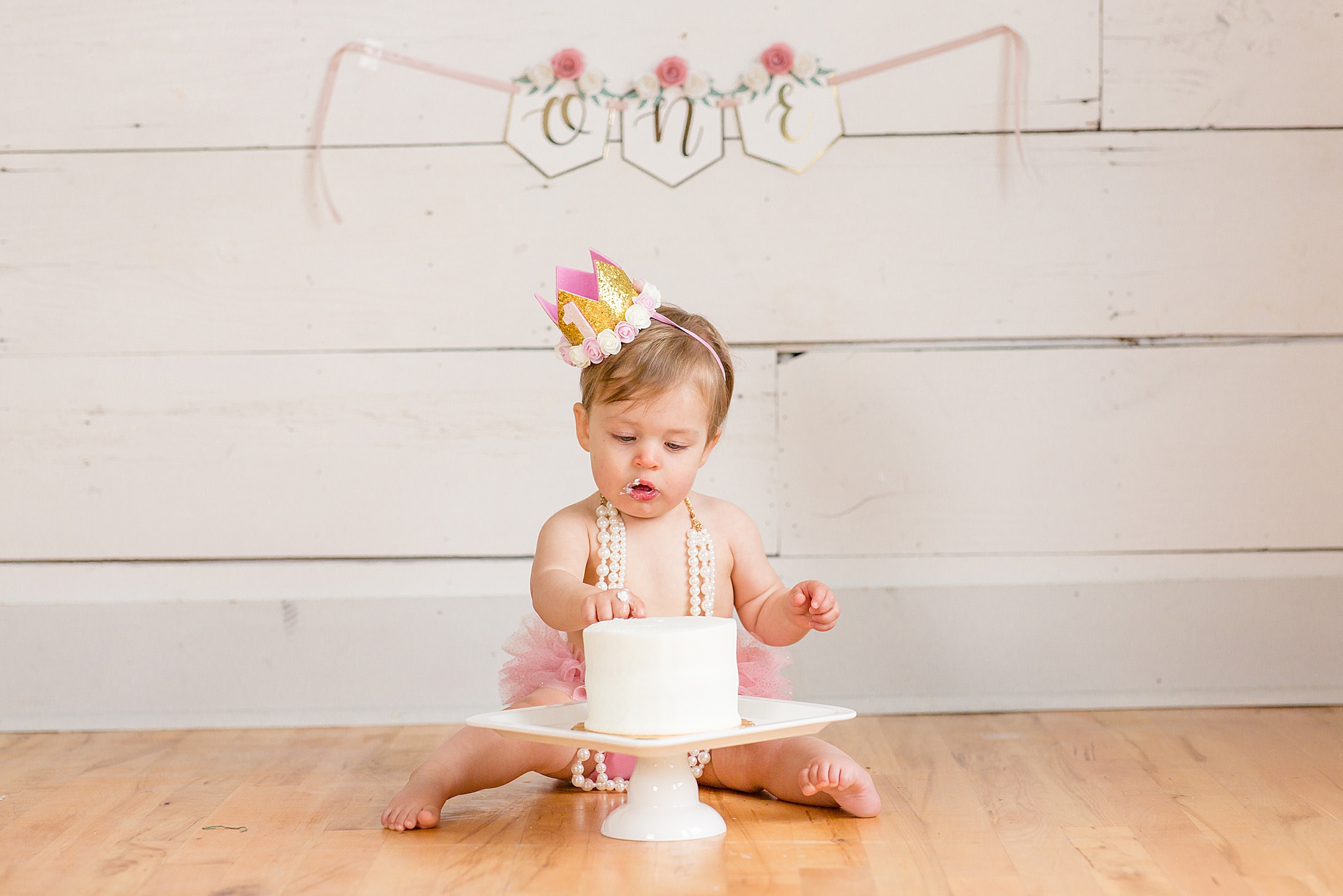 baby sits behind cake testing icing