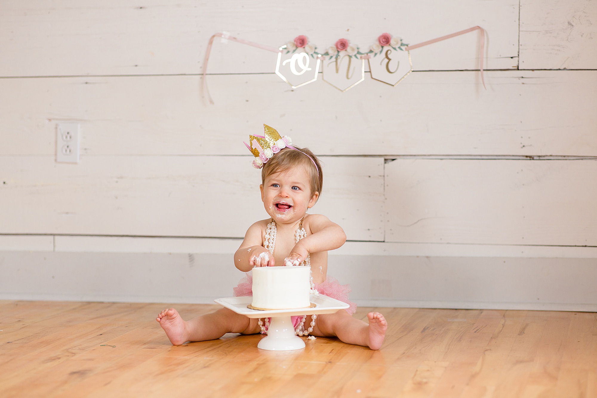 baby plays with cake in natural light studio in McKinney TX