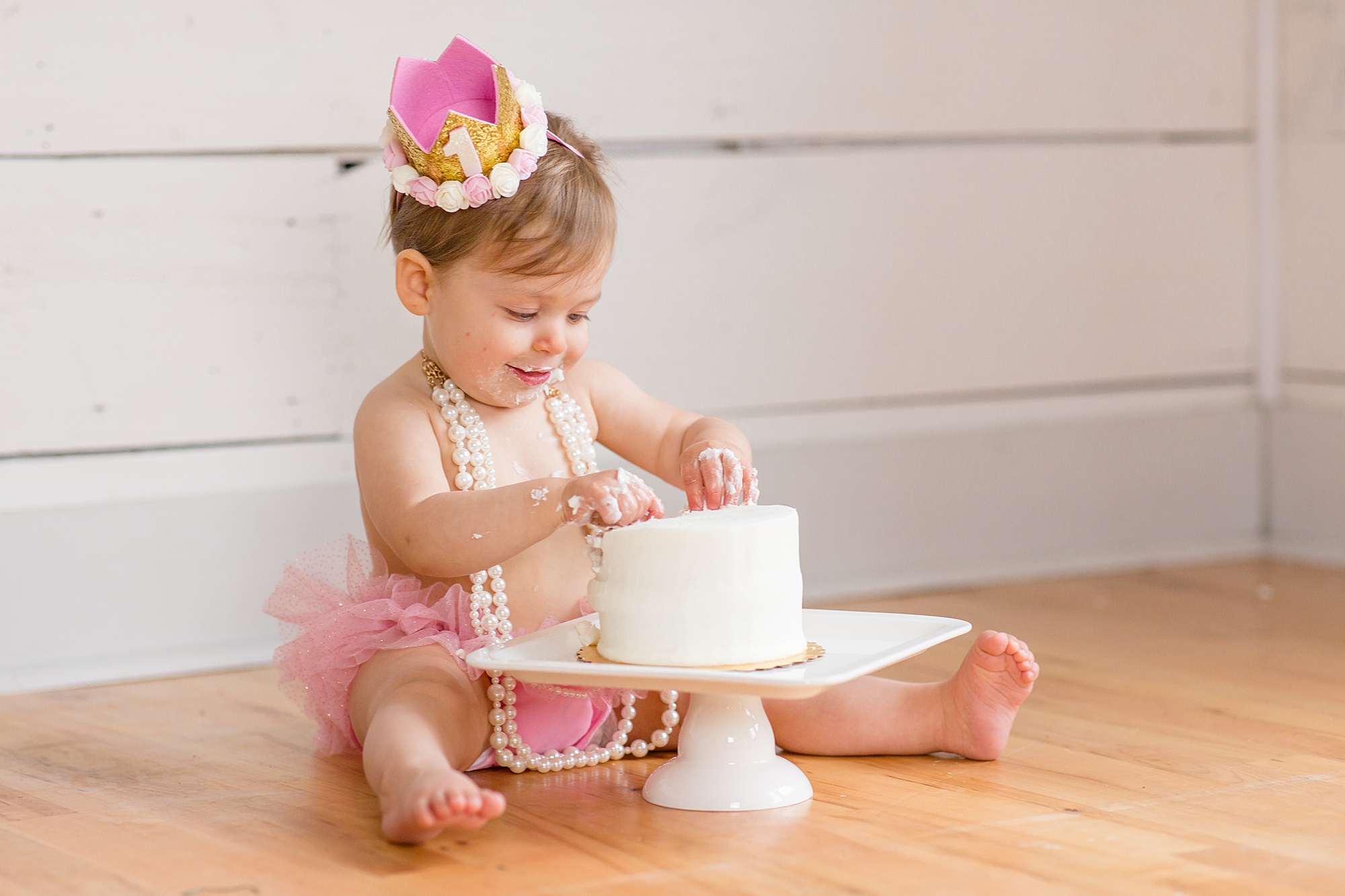 one year old plays with cake