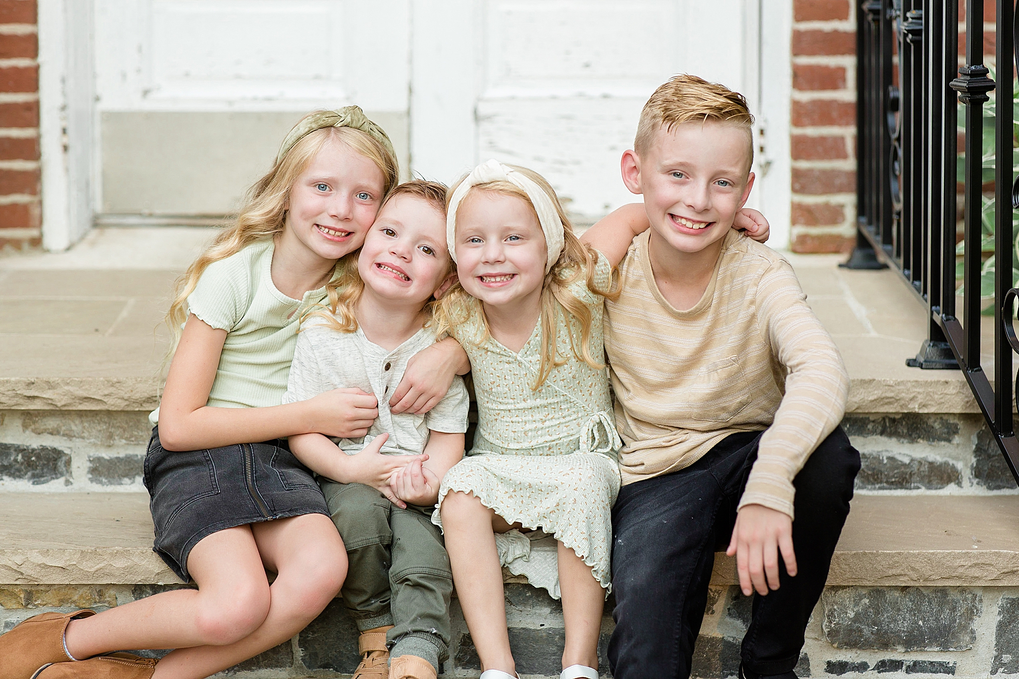 four kids hug on steps during Spring Hill family portraits