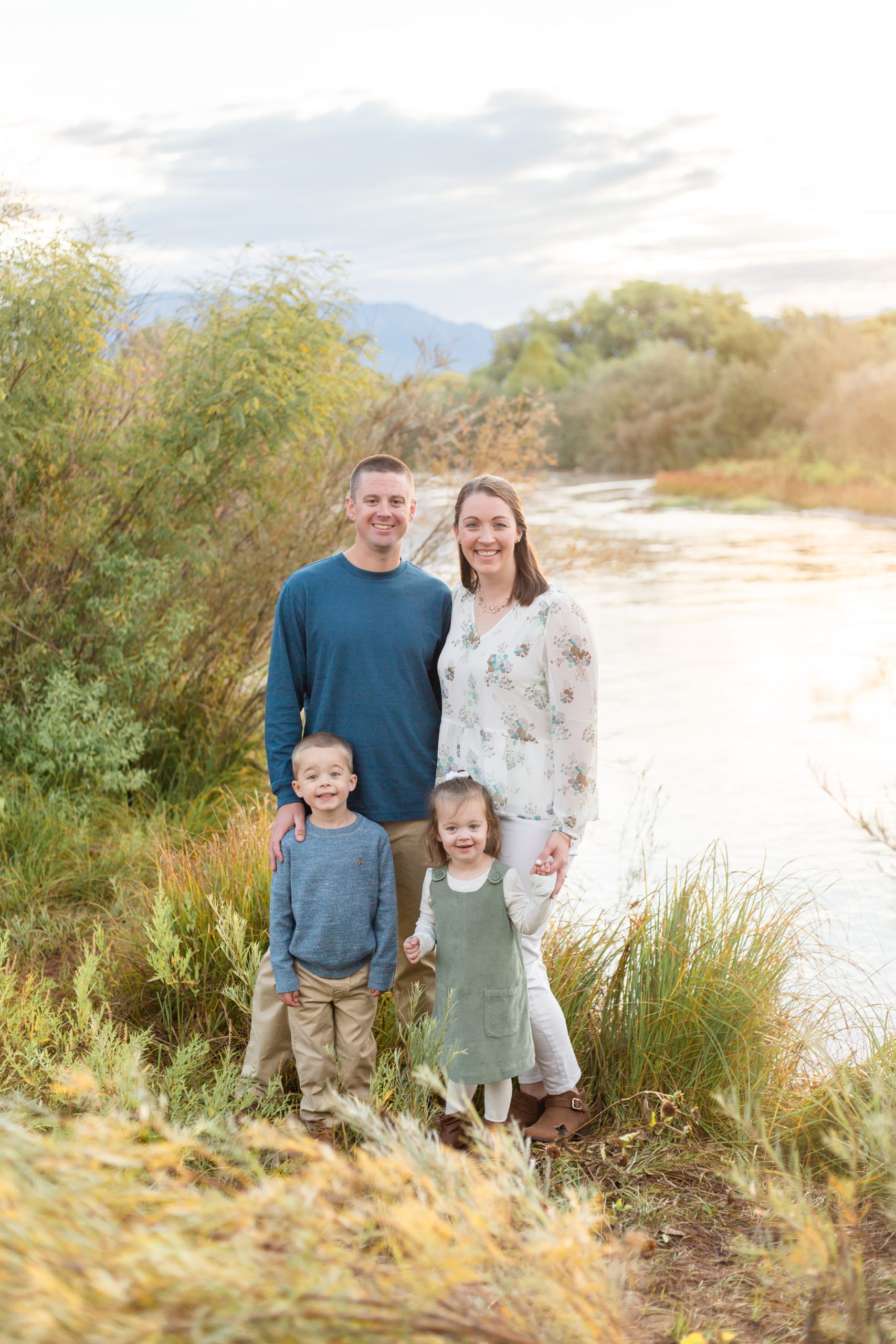 family poses in front of river in albuquerque, nm before balloon festival with family photographer Rebecca Rice Photography 