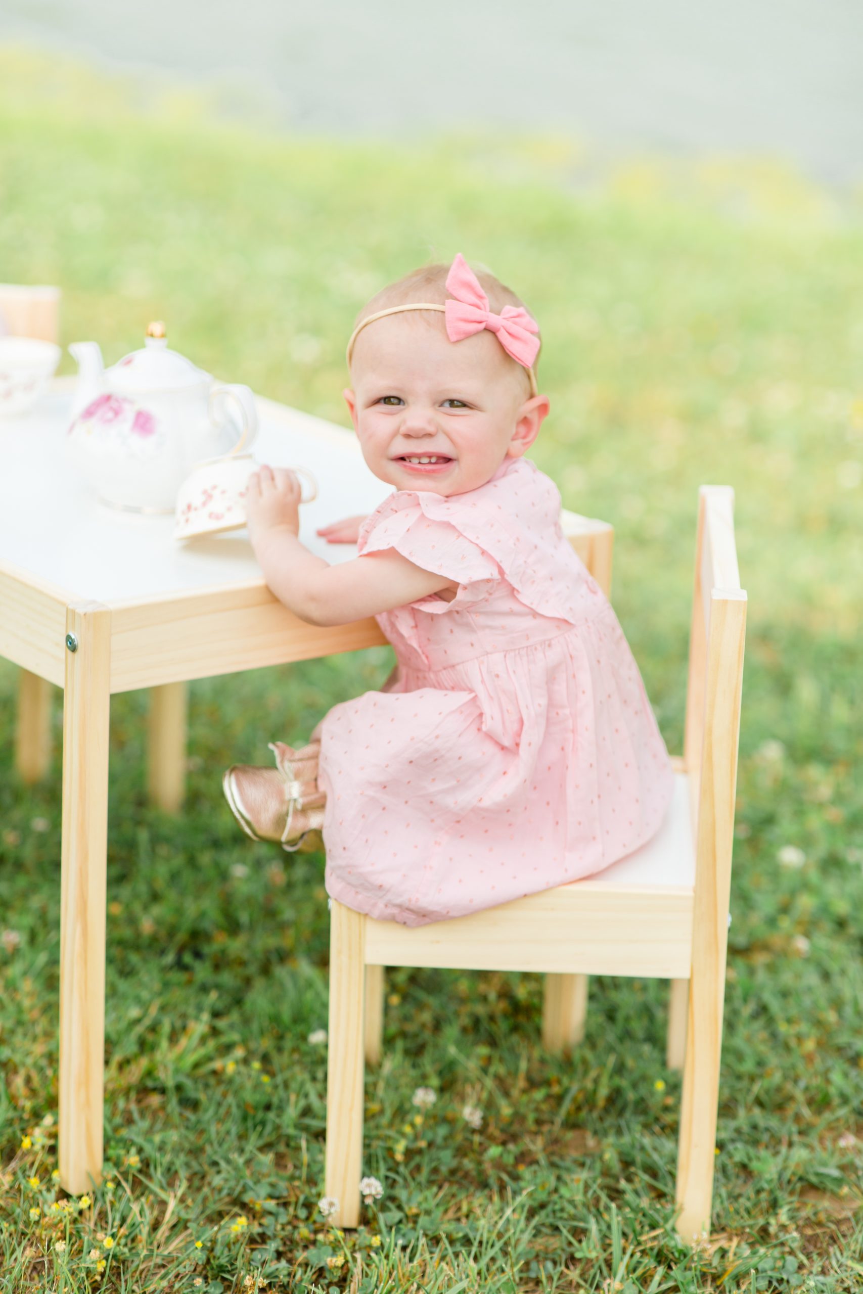 One year old sits at a tea party set up for first birthday smash cake session at Harlinsdale Farm in Franklin, TN with family photographer and educator Rebecca Rice of Rebecca Rice Photography. Click to see more from this sweet session on the blog now! 