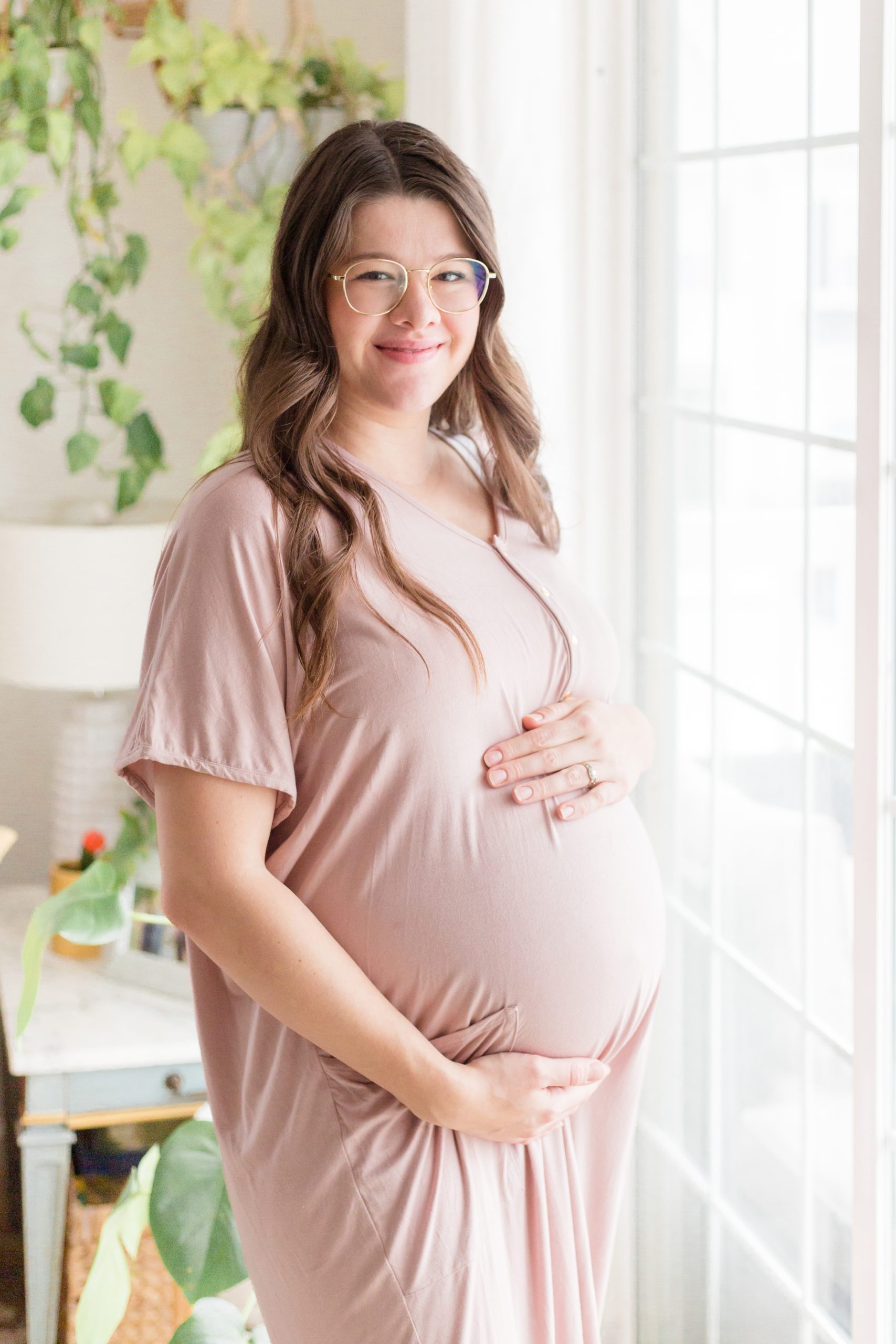 Expecting mama in pink dress holds pregnant belly during lifestyle maternity session with Rebecca Rice of Rebecca Rice Photography. Click to see more from this sweet session live on the blog now! 