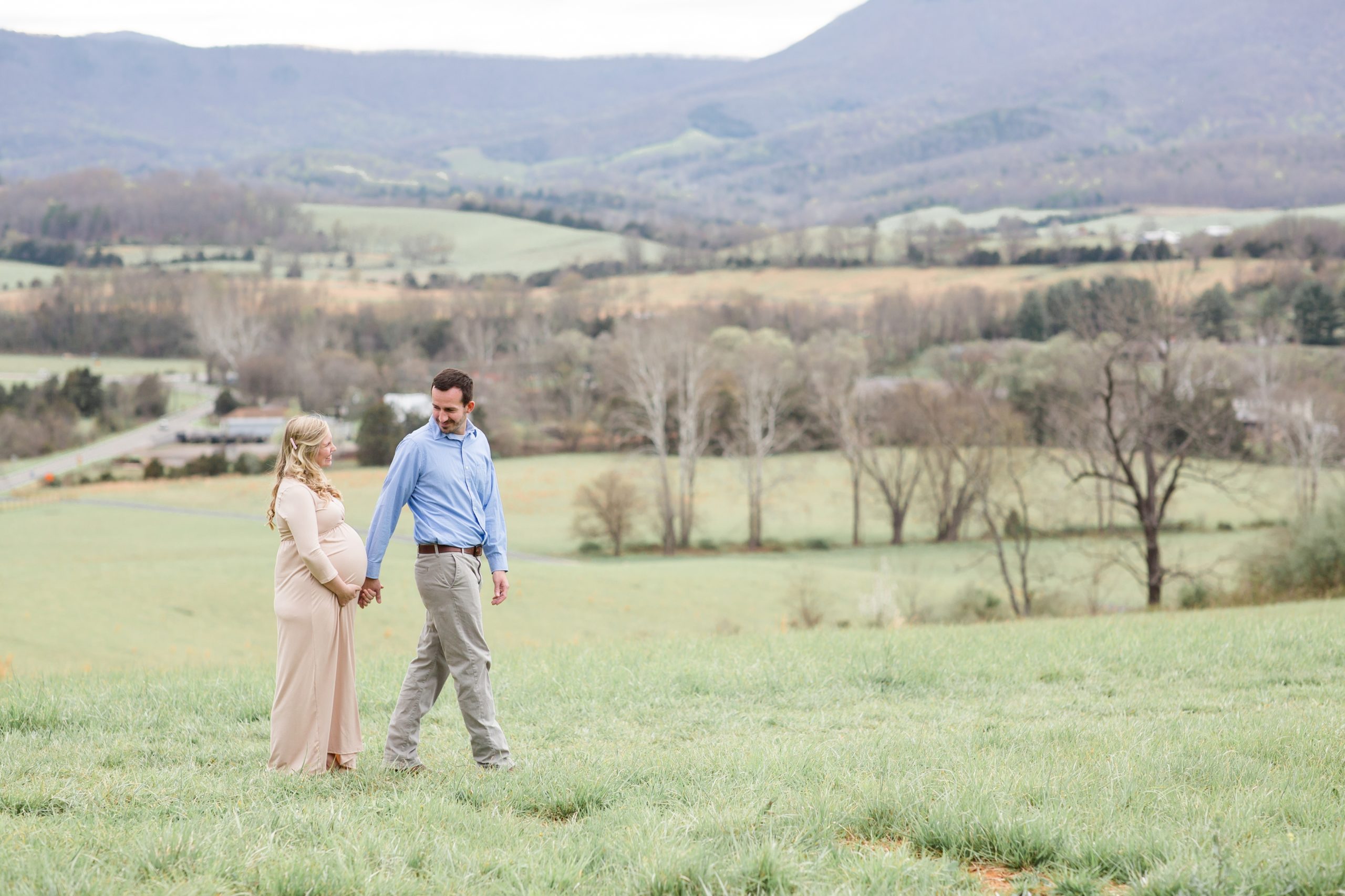 Mom and dad expecting new baby walk along field during mountainside maternity session with family photographer and educator Rebecca Rice of Rebecca Rice Photography. This sweet maternity session was featured on the blog and on my monthly membership, Behind the Lens. Click to read more about this sweet session live on the blog now! 