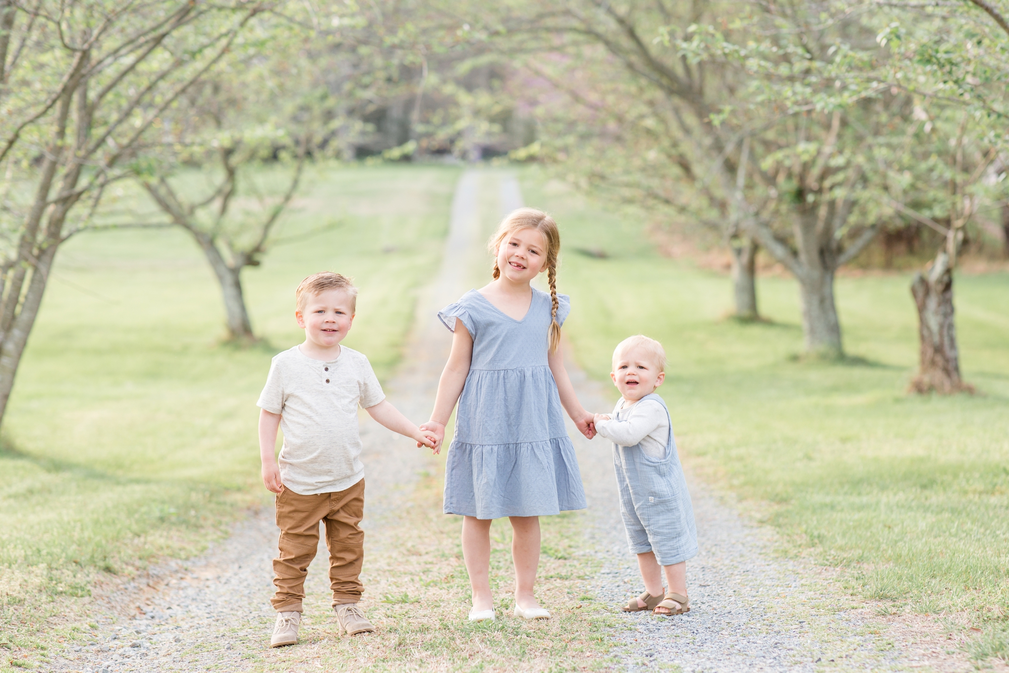 Siblings pose on gravel road during family portrait session in the spring on farm in Richmond, VA with family photographer and educator Rebecca Rice of Rebecca Rice Photography. Click to see more from this sweet session live on the blog now. 