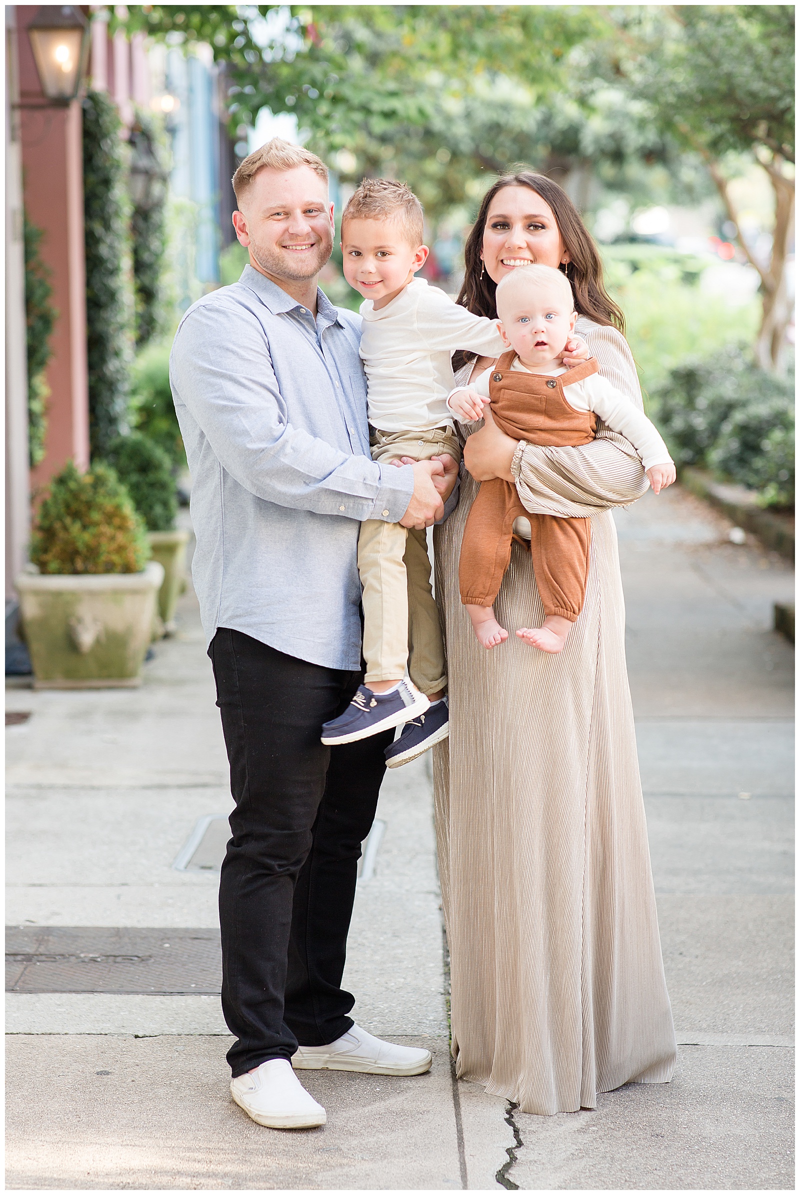 Family of four wear tan and brown neutrals with a pop of light blue for their family session in Charleston, SC!