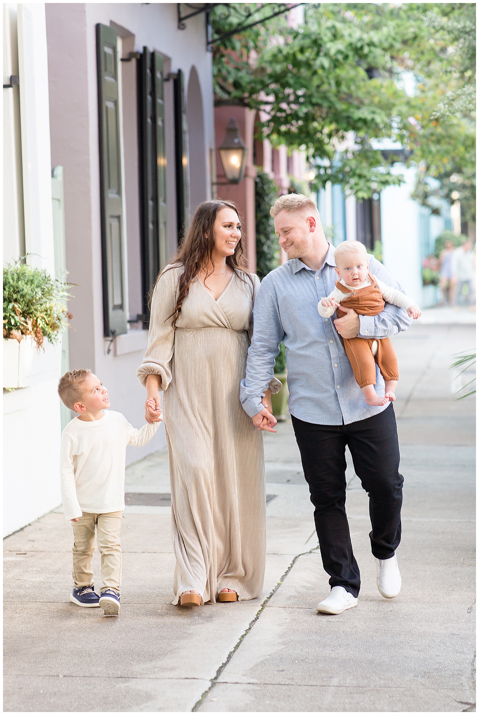 Family of 4 walks down the streets of Rainbow Row as Charleston family photographer, Rebecca Rice, captures their sweetness as they look at each other.