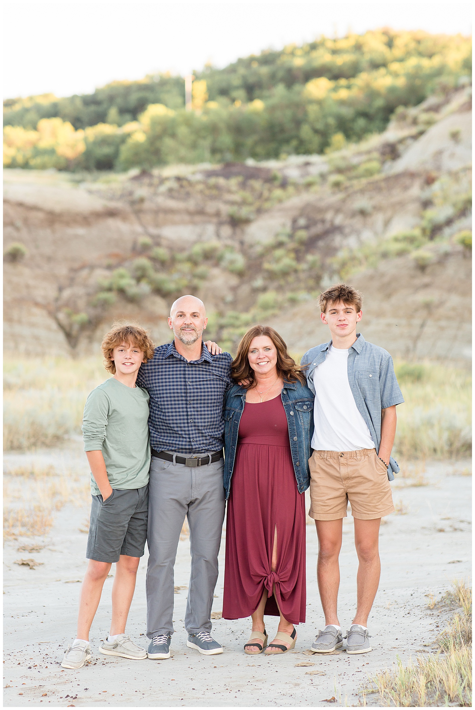 Family coordinates outfits for family session in North Dakota wearing denim, burgundy, green, grey, and white. Taken by Rebecca Rice Photography.