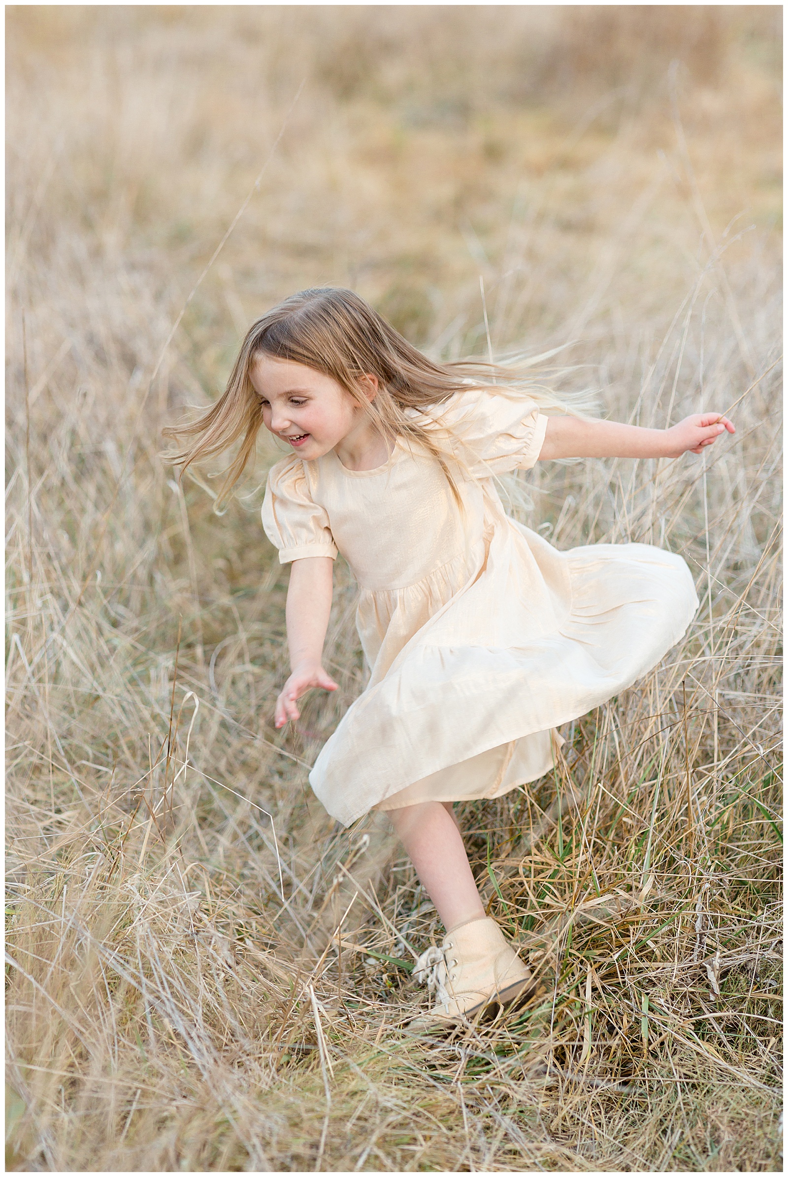 Young girl with brown hair twirls joyfully in a Nashville field with her gold/cream dress in front of Rebecca Rice's camera.  Click now to see more on the blog!