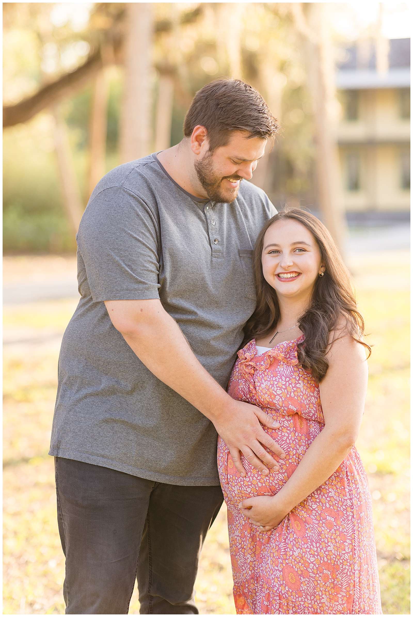 Pregnant momma looks at the camera of Rebecca Rice Photography holding her belly while her husband looks down at her and holds the belly smiling!
-rebeccaricephoto.com