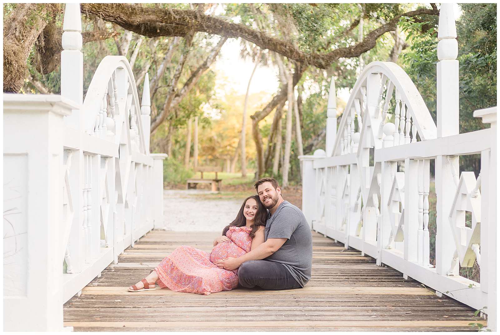 Couple sits on wooden bridge and smiles at the camera of Rebecca Rice Photography who captures this Florida maternity session.  Pregnant momma sits back into her husbands lap as they lean into each other and smile.  See more from this session on the blog today!
-rebeccaricephoto.com