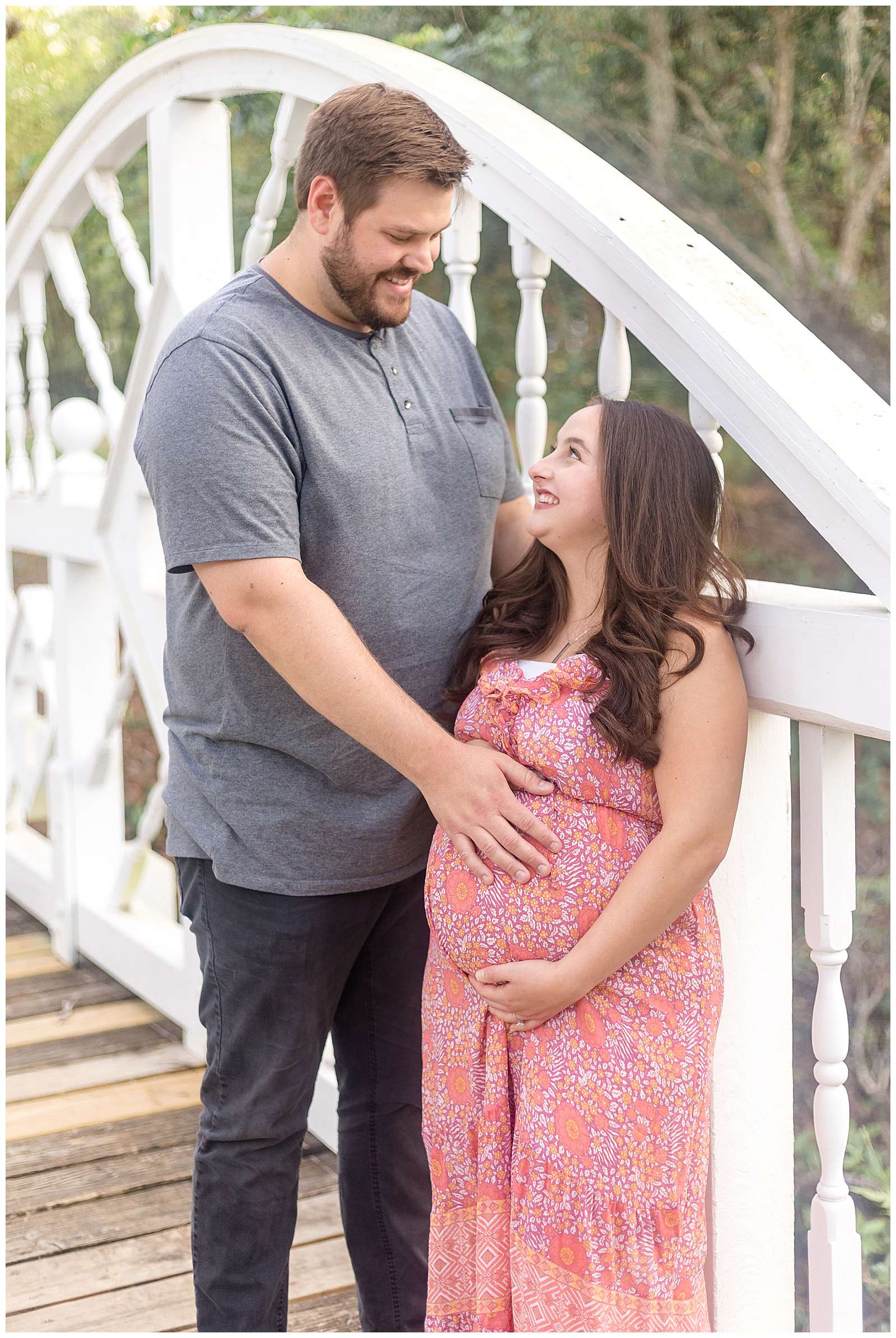 A couple with a BIG height difference stands on a bridge looking at each with smiles and anticipation for their baby on the way!  Click to see more of this height difference couple captured by Rebecca Rice Photography on the blog today!
-rebeccaricephoto.com
