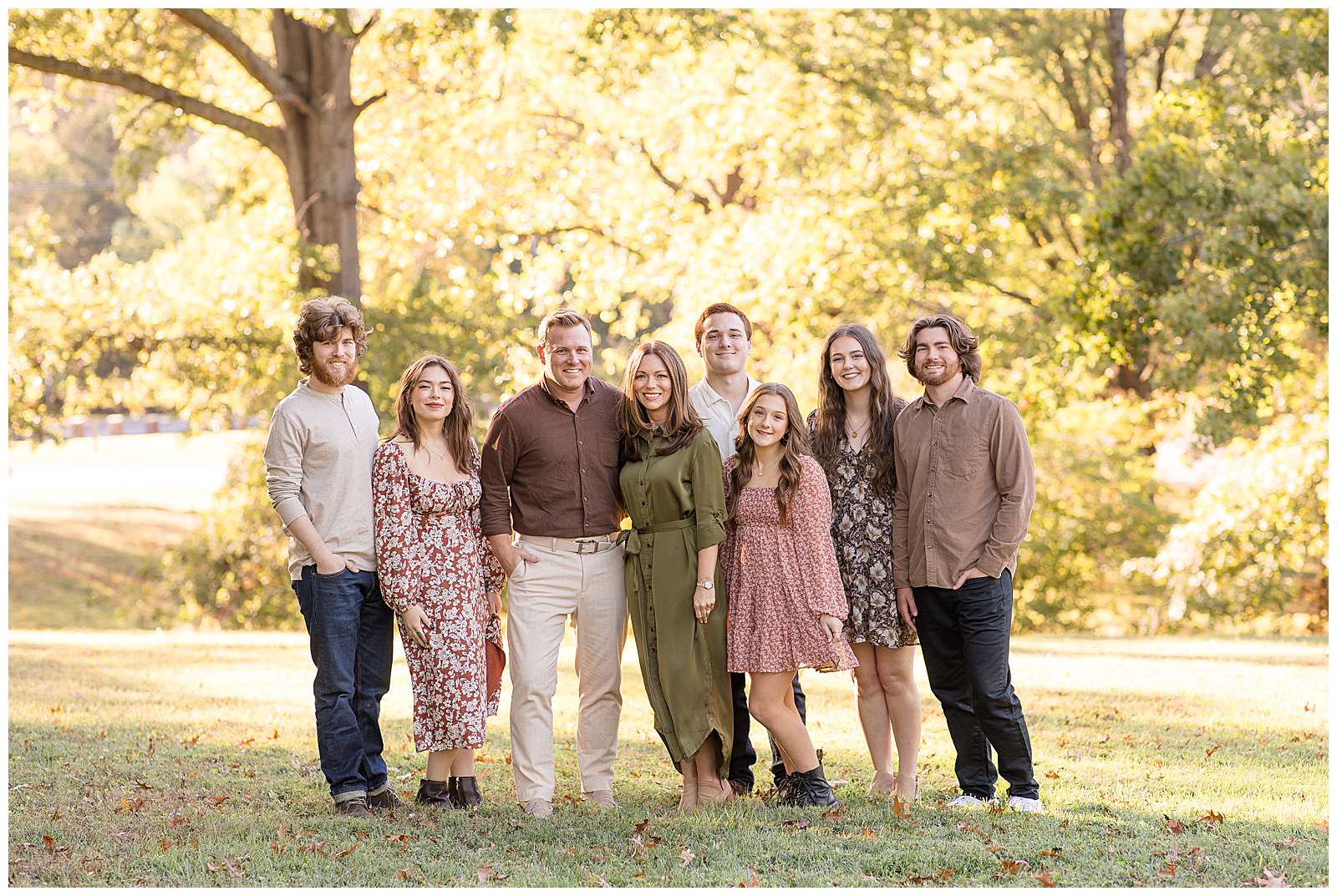 Fall Family Session with grown children to show how to do family sessions with photography educator, Rebecca Rice.  The family coordinates in olive greens, cranberry, brown, tan, and denim colors.  Mom and Dad stand in the middle with 4 children on their right and 2 on their left.